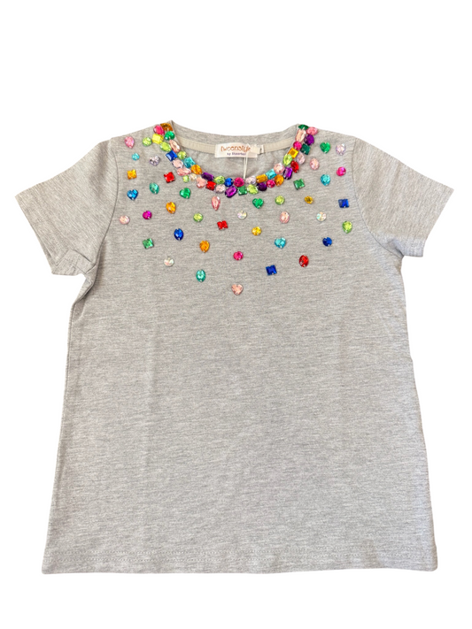 A light gray short-sleeve t-shirt with a colorful beaded neckline, featuring various small, multi-colored heart and star embellishments. The shirt is laid flat against a solid white background.