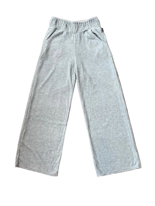Light glacier blue heather sweatpants with an elastic waistband, laid flat on a brown wood floor.