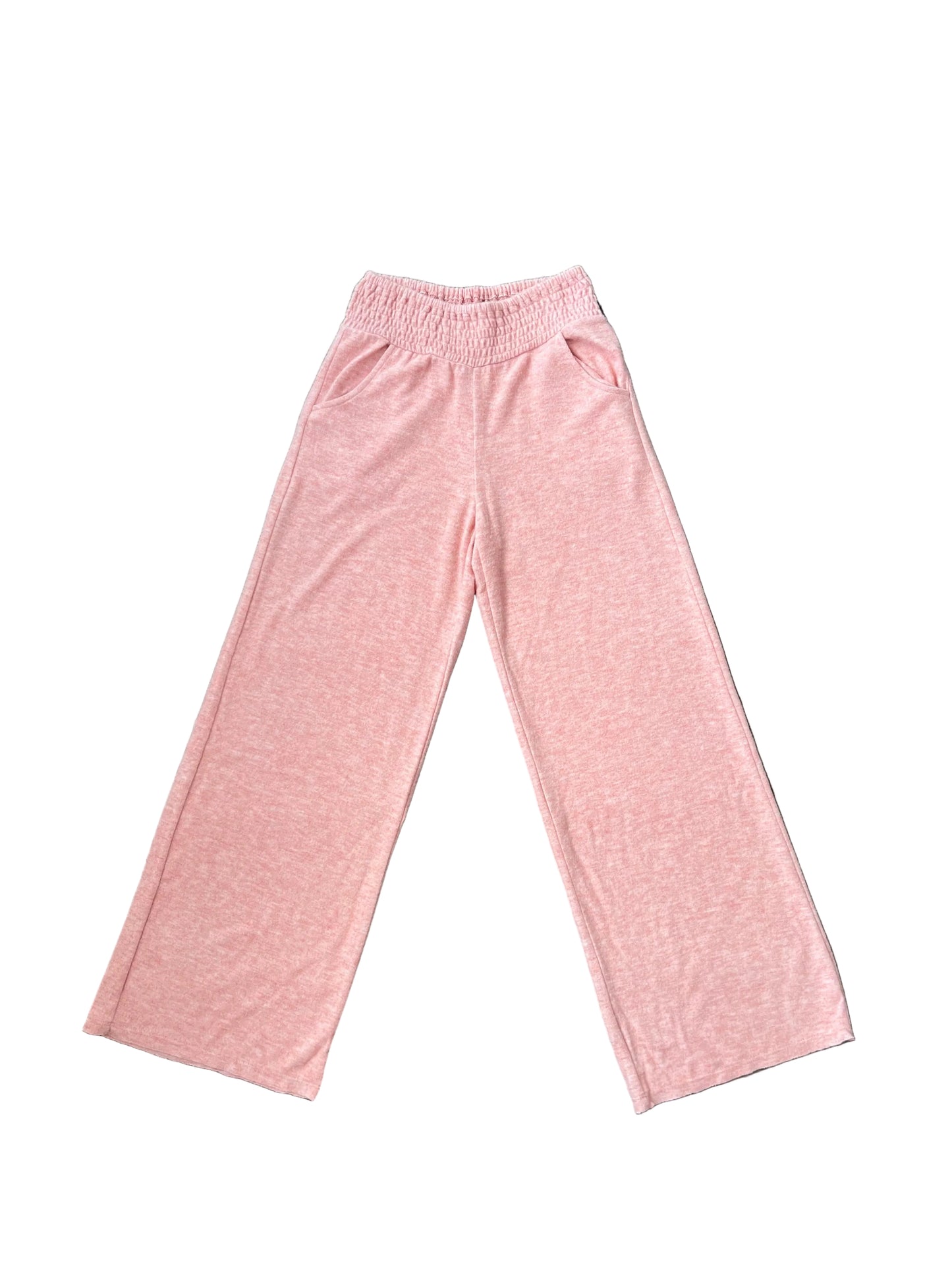 A pair of heathered pink wide-leg sweatpants with an elastic waistband, laid flat on a dark wood floor.