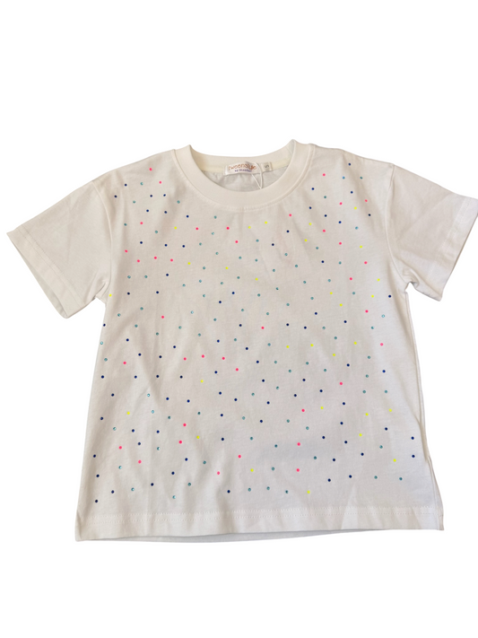 An off-white short-sleeve t-shirt with a scattered pattern of tiny multicolored polka dots, laid flat against a white background.