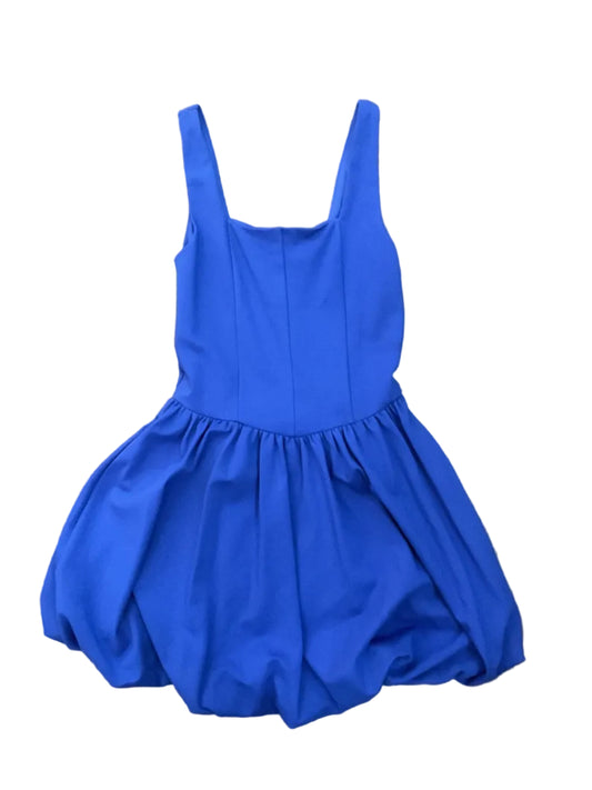 A bright royal blue sleeveless dress with a gathered empire waist and wide straps, bubble bottom, laid flat on a brown wood floor.